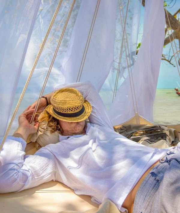 Mann liegend im TiiPii Bed mit Sonnenhut vor dem Gesicht